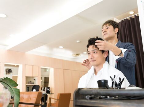ヘアスタイルを整えるスタッフ